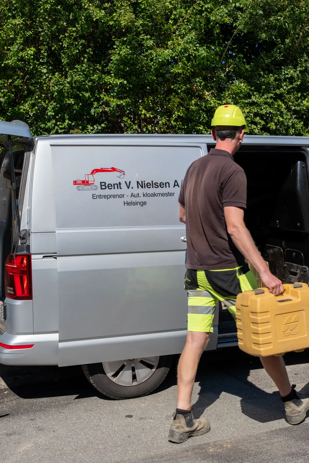 Medarbejder bærer værktøjskasse til firmabilen